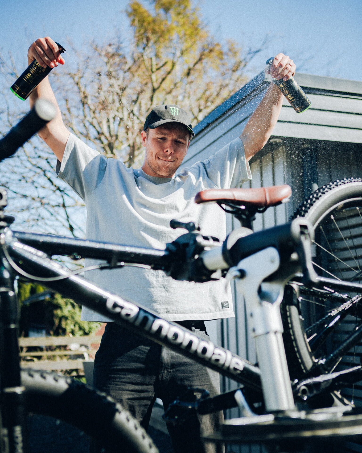 Man tvättar mountainbike med sprayflaska.